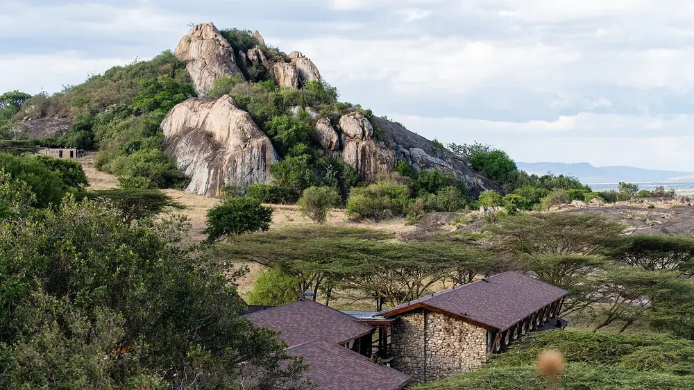 Lobo Wildlife Lodge: low stone buildings among acacias at the foot of large, rounded granite kopjes