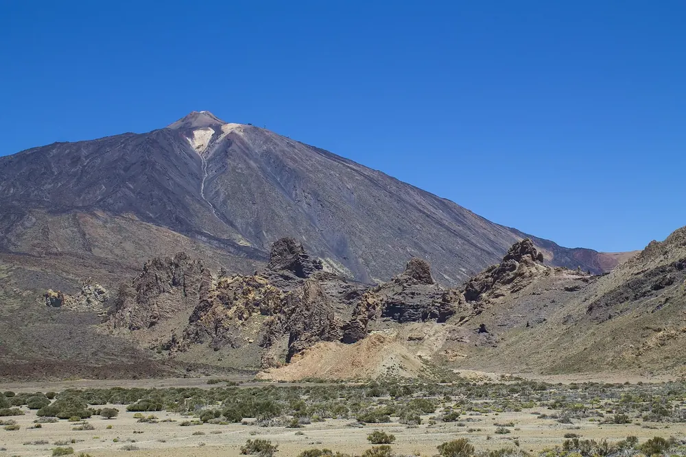 Pico del Teide and Montaña Blanca in Teide National Park above the barren Las Cañadas plateau under a deep blue sky