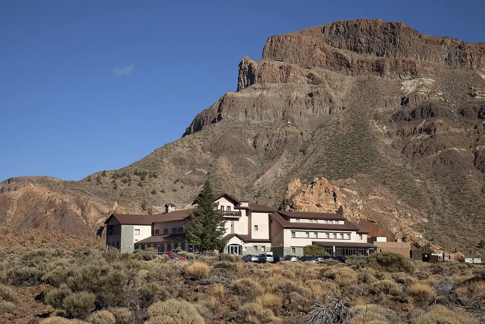 Parador de Las Cañadas del Teide in Teide National Park: hotel building at the foot of the rugged rock faces of Alto de Guajara