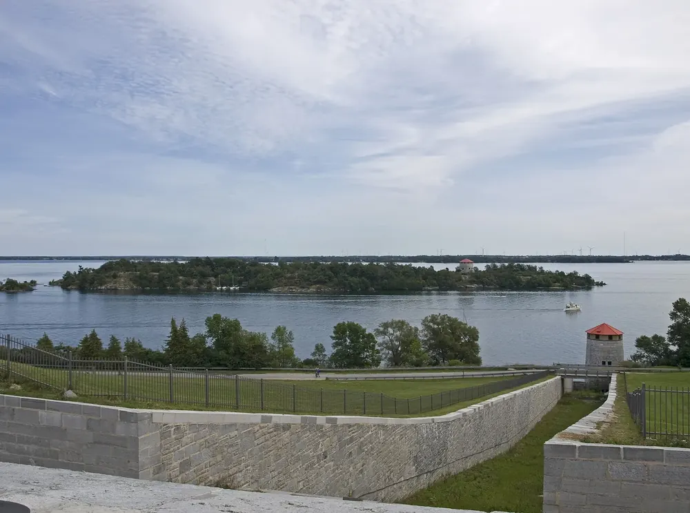 View from the wall of Fort Henry to forested Cedar Island, an island of Thousand Islands National Park, with Cathcart Tower in the St. Lawrence River