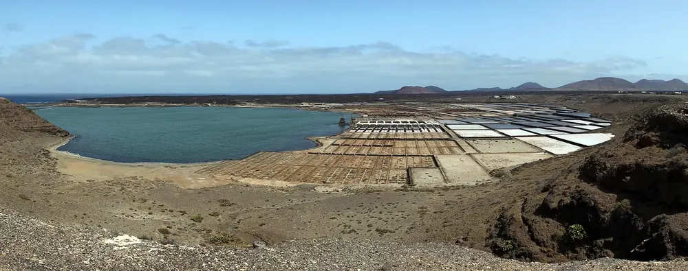 Salinas de Janubio: lagoon and chequerboard salt pans between dark volcanic hills on the coast