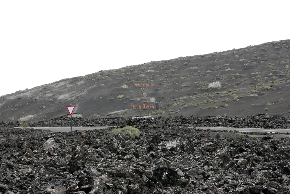 Lava field at Tinguatón on the LZ-67: black, jagged chunks of lava in front of a bare volcanic slope