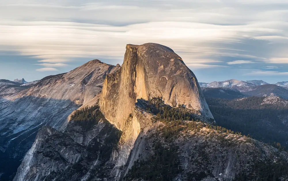 Half Dome from Glacier Point in Yosemite National Park: the distinctive granite dome in warm evening light above wooded valleys
