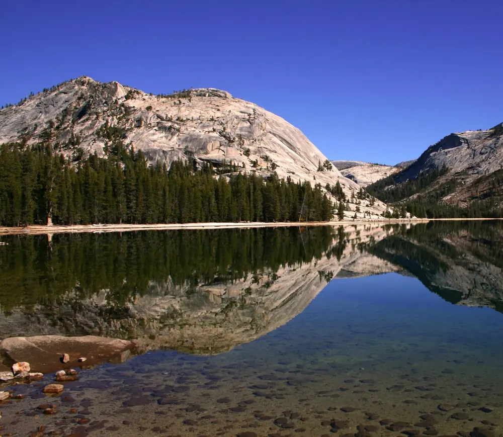 Tenaya Lake in Yosemite National Park: a crystal-clear mountain lake reflecting a granite dome and dark conifer forest