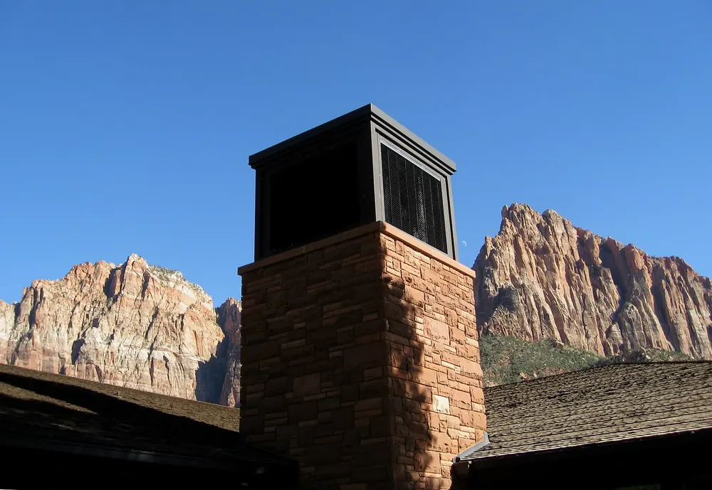 Zion Canyon Visitor Center: a sandstone chimney tower in front of the reddish rock peaks of Zion Canyon