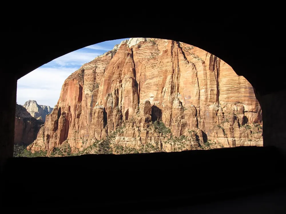 Gallery window in the Zion–Mount Carmel Tunnel in Zion National Park: looking out of the dark tunnel at a red sandstone wall