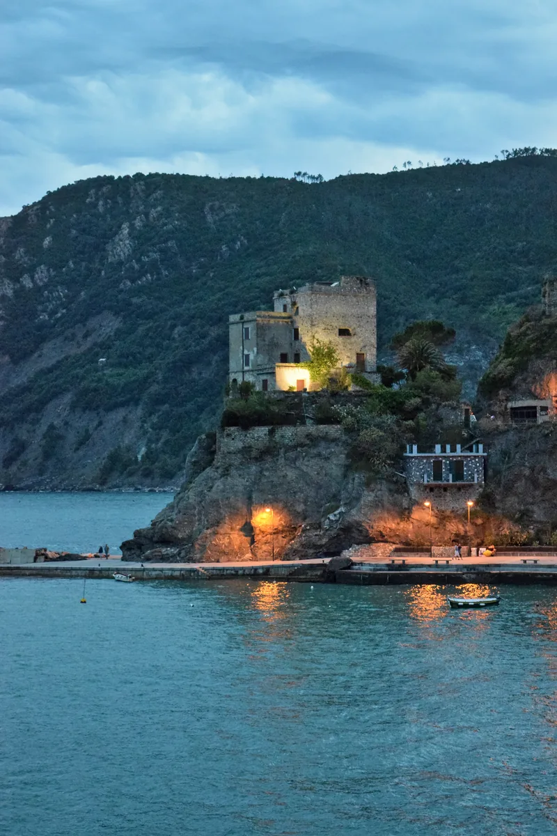 The Torre Aurora in Monterosso al Mare on its rock above the water, lit up in the evening