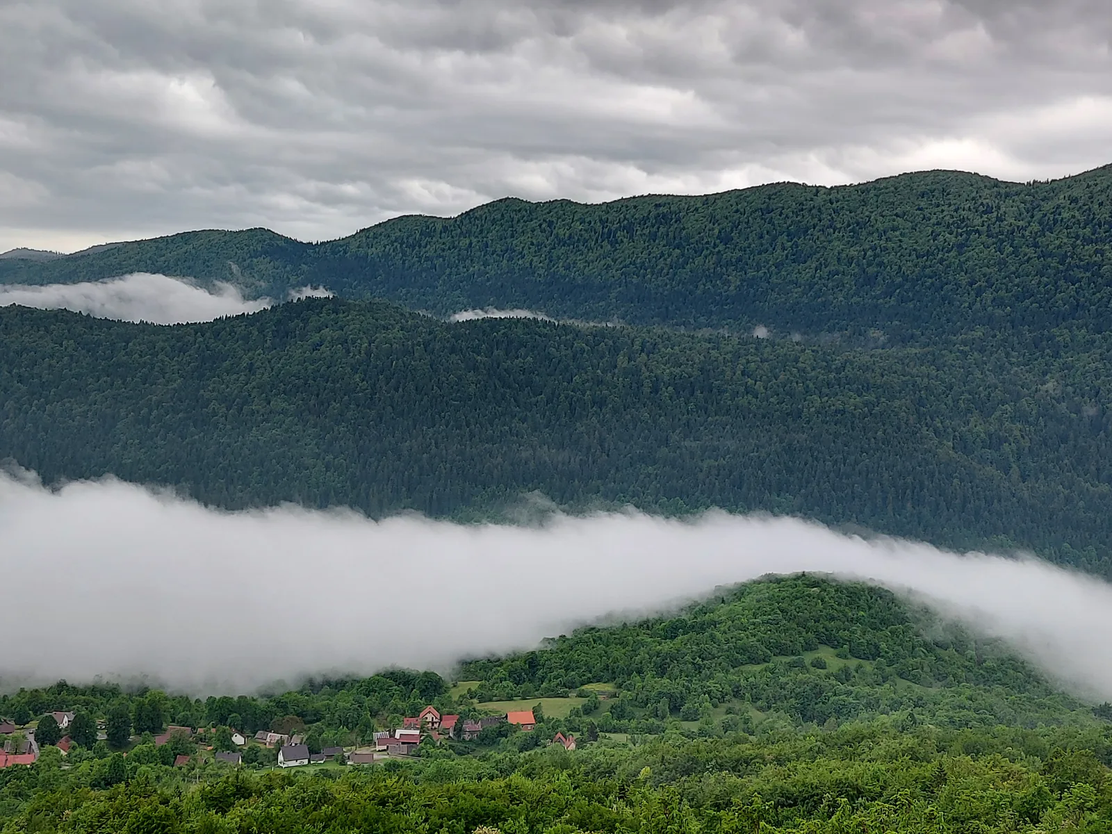 Wooded ridges in Northern Velebit National Park above a band of mist