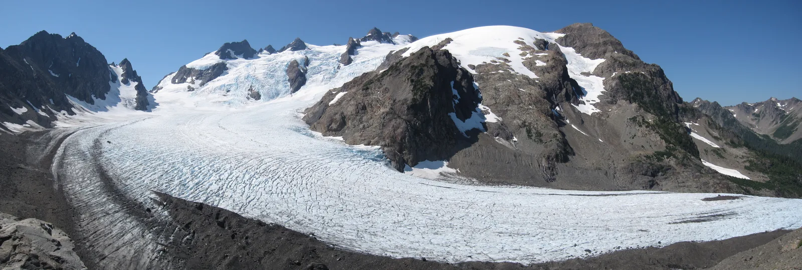 Panorama of the Blue Glacier in Olympic National Park from the lateral moraine: the broad glacier tongue below the rocky summits of Mount Olympus