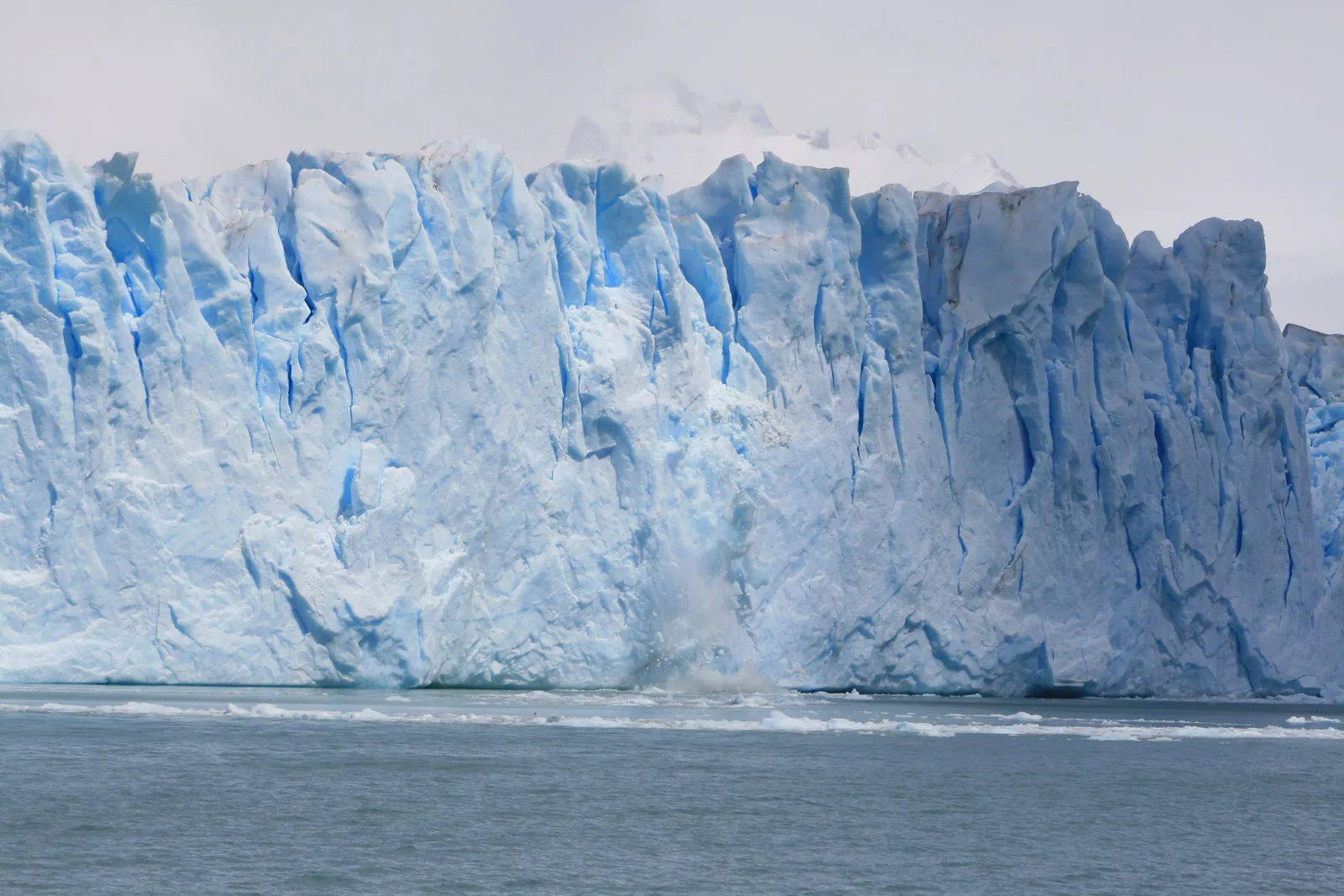 The steep, jagged ice front of the Perito Moreno Glacier in Los Glaciares National Park, with ice floating on the lake in front
