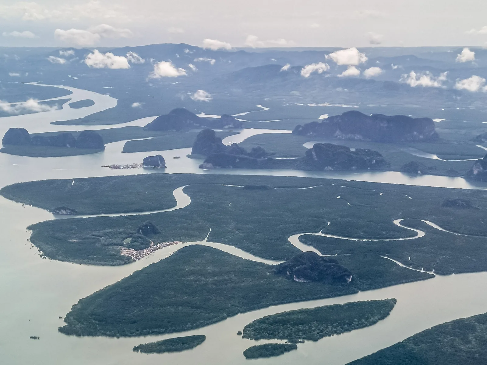 Aerial view of Phang Nga Bay with mangrove islands, winding channels and limestone islands under clouds