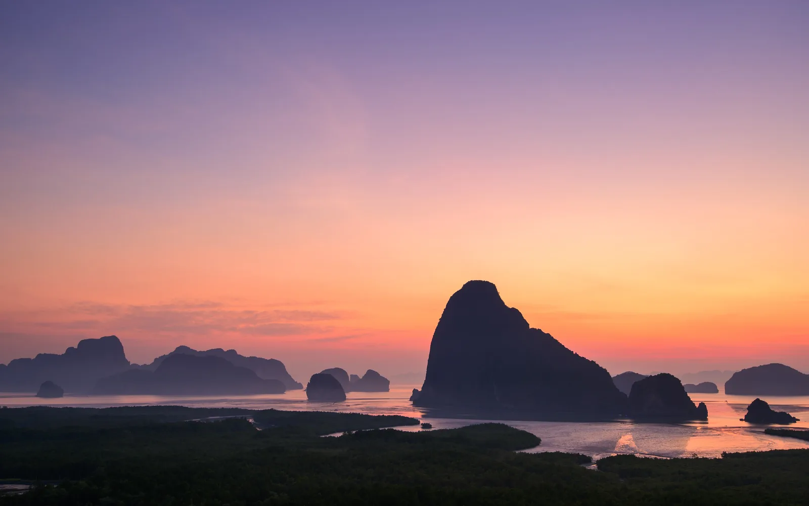 Dawn over Phang Nga Bay, with the dark outlines of the limestone islands and mangroves in front