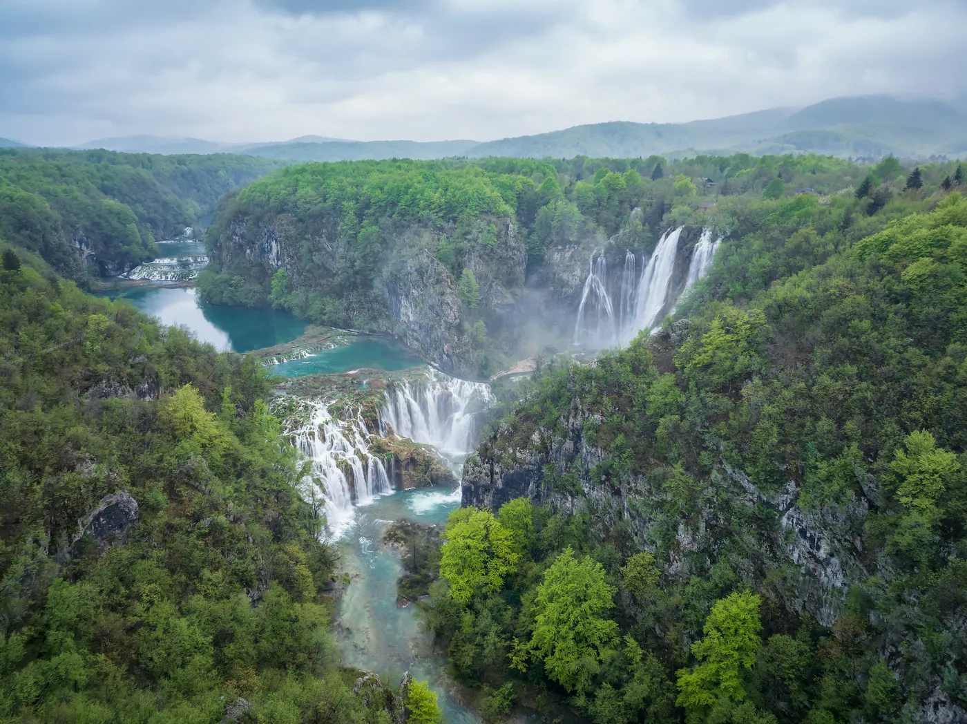 Plitvice Lakes National Park from the air in spring: Veliki slap and the Sastavci cascades between green wooded slopes