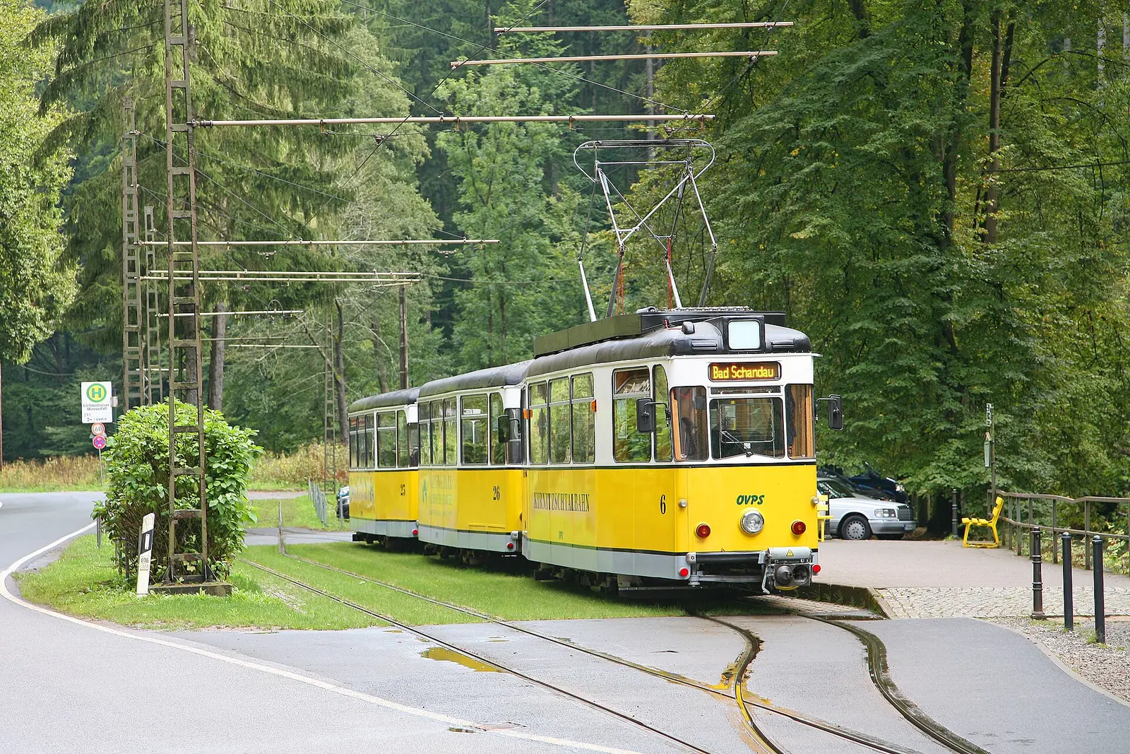 Yellow tram of the Kirnitzschtal line at its terminus in a wooded valley