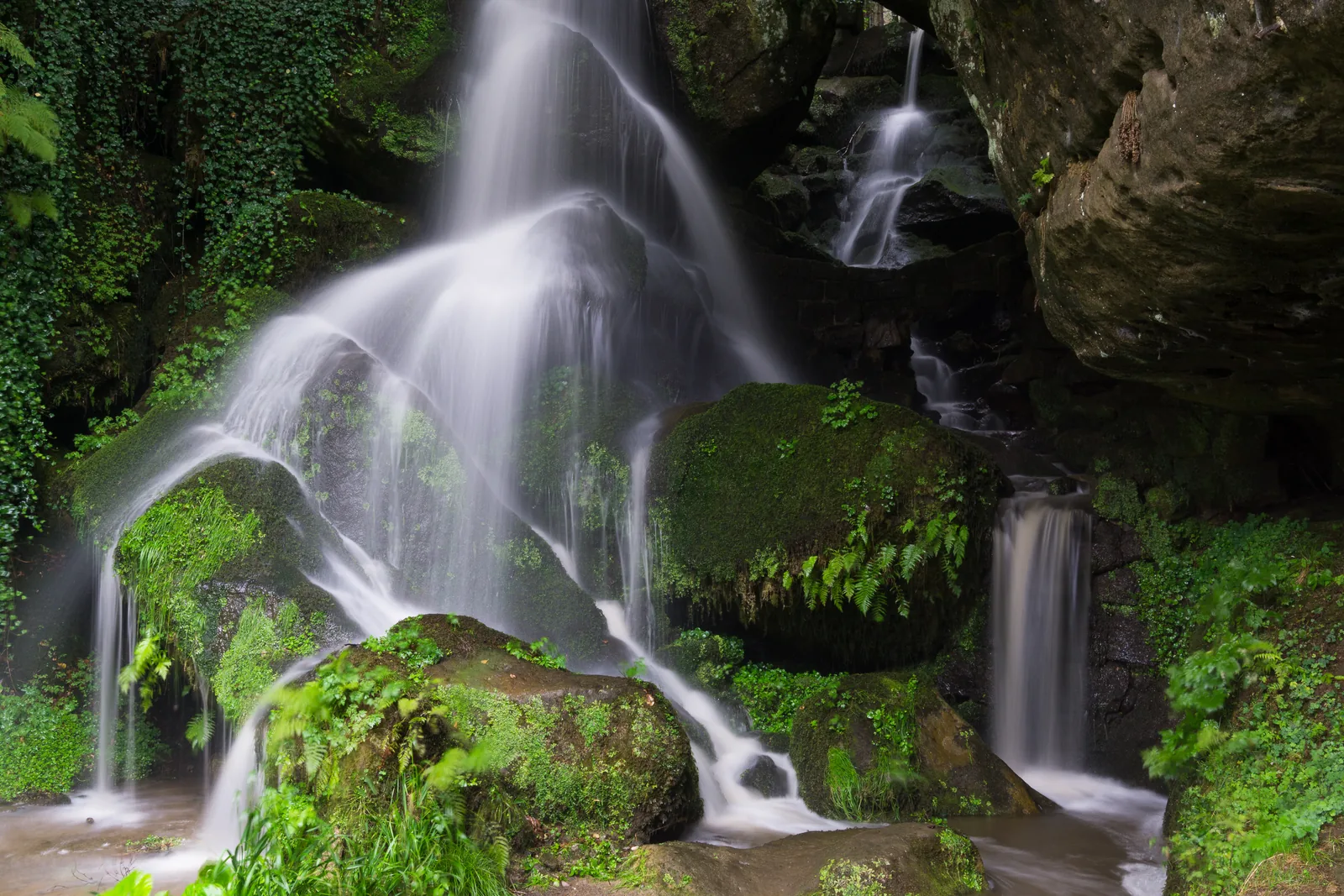 The Lichtenhain Waterfall in the Kirnitzschtal pours over mossy sandstone rocks, Saxon Switzerland National Park
