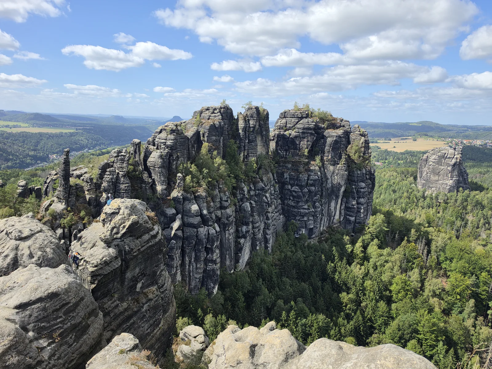 The fissured rock ridge of the Schrammsteine rises from the wooded ridge in Saxon Switzerland National Park