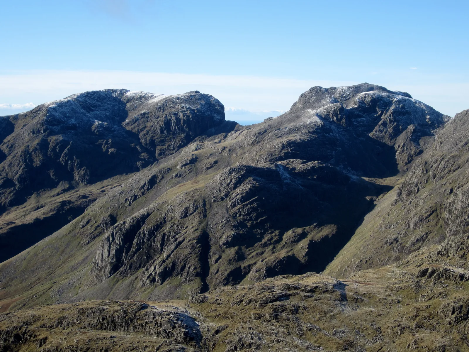 Scafell and Scafell Pike in the Lake District National Park seen from the summit of Bowfell, with a dusting of fresh snow on the tops