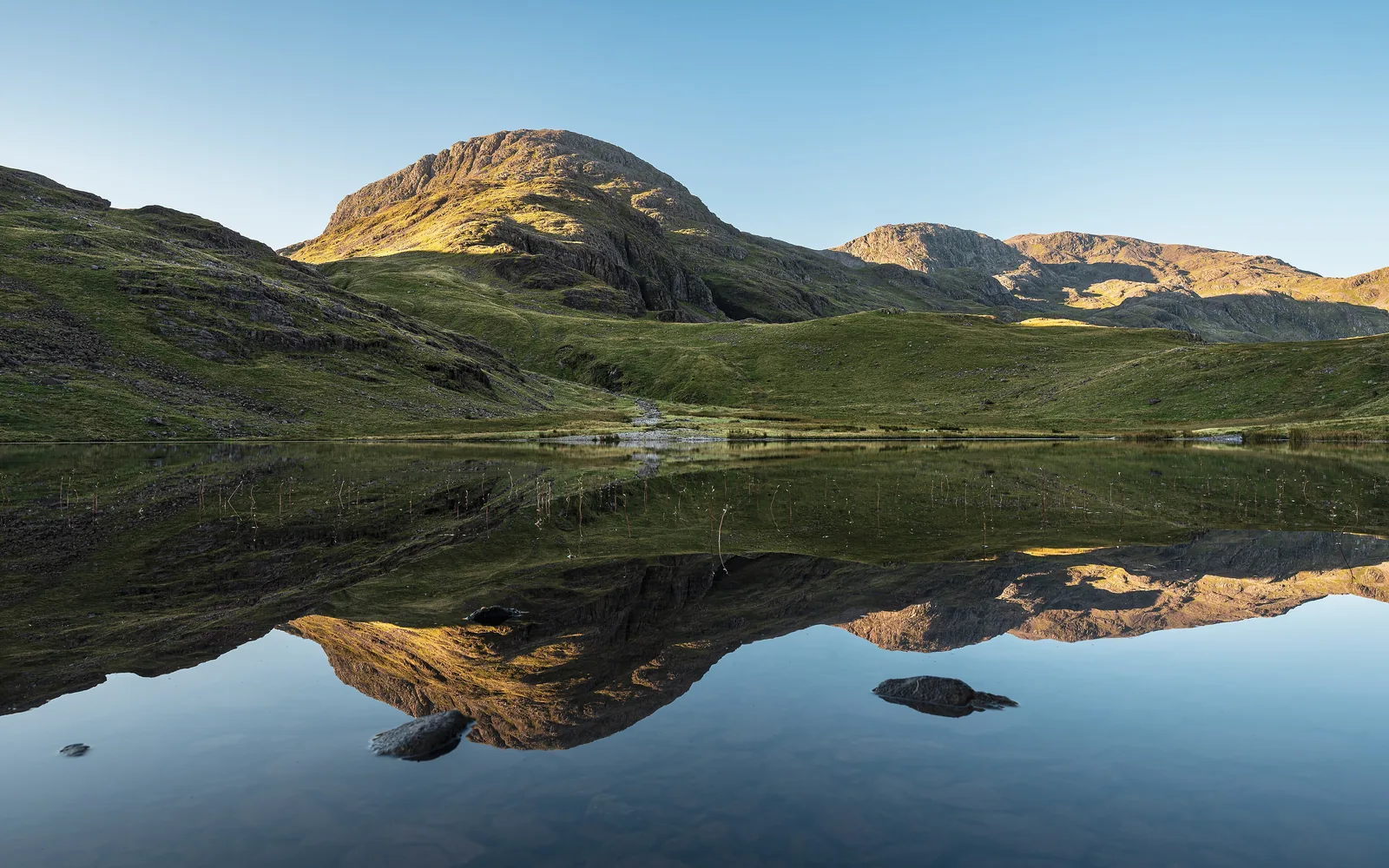 Styhead Tarn on the route from Borrowdale in morning light, with Great End, Broad Crag and Scafell Pike behind, in the Lake District National Park