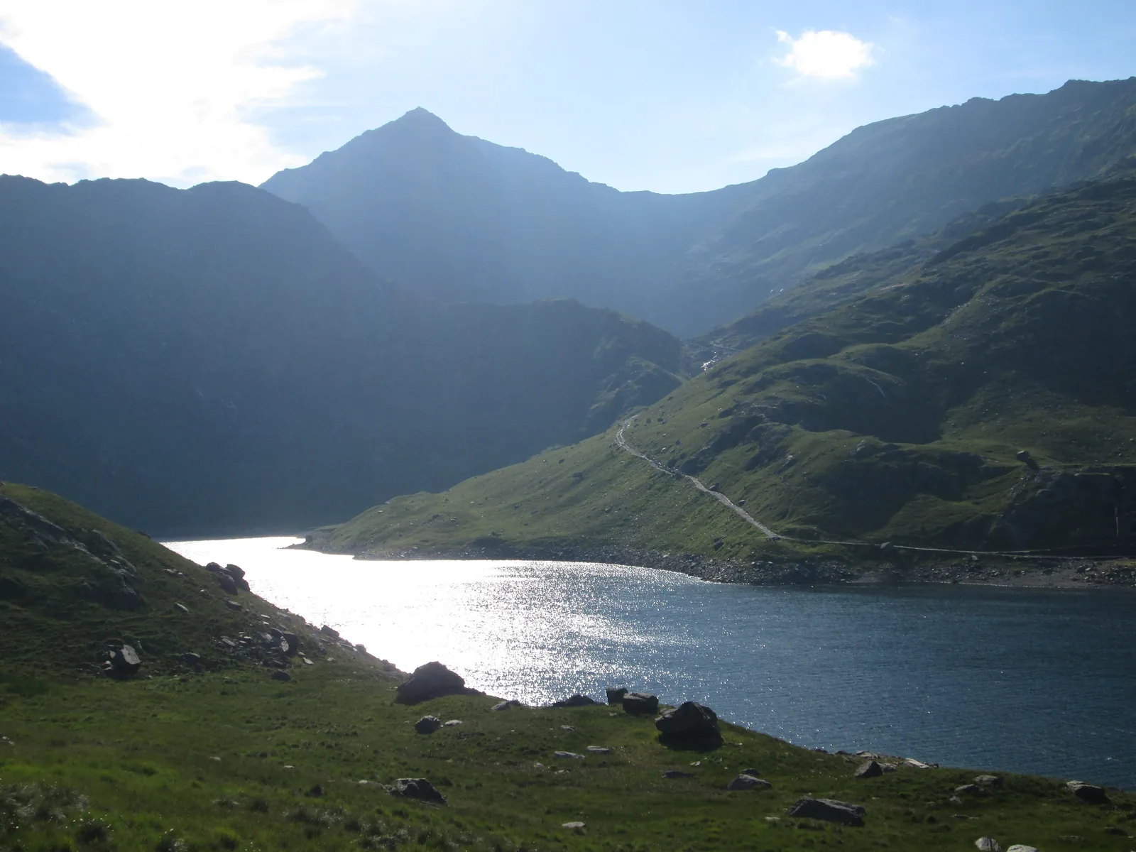 The lake Llyn Llydaw in Snowdonia National Park against the light, with the pointed summit of Snowdon (Yr Wyddfa) above