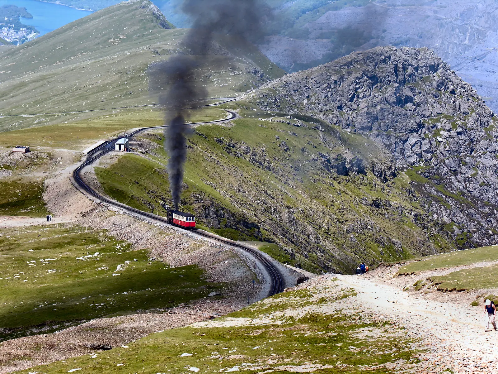 A steam train of the Snowdon Mountain Railway at Clogwyn station in Snowdonia National Park, the mountainside behind