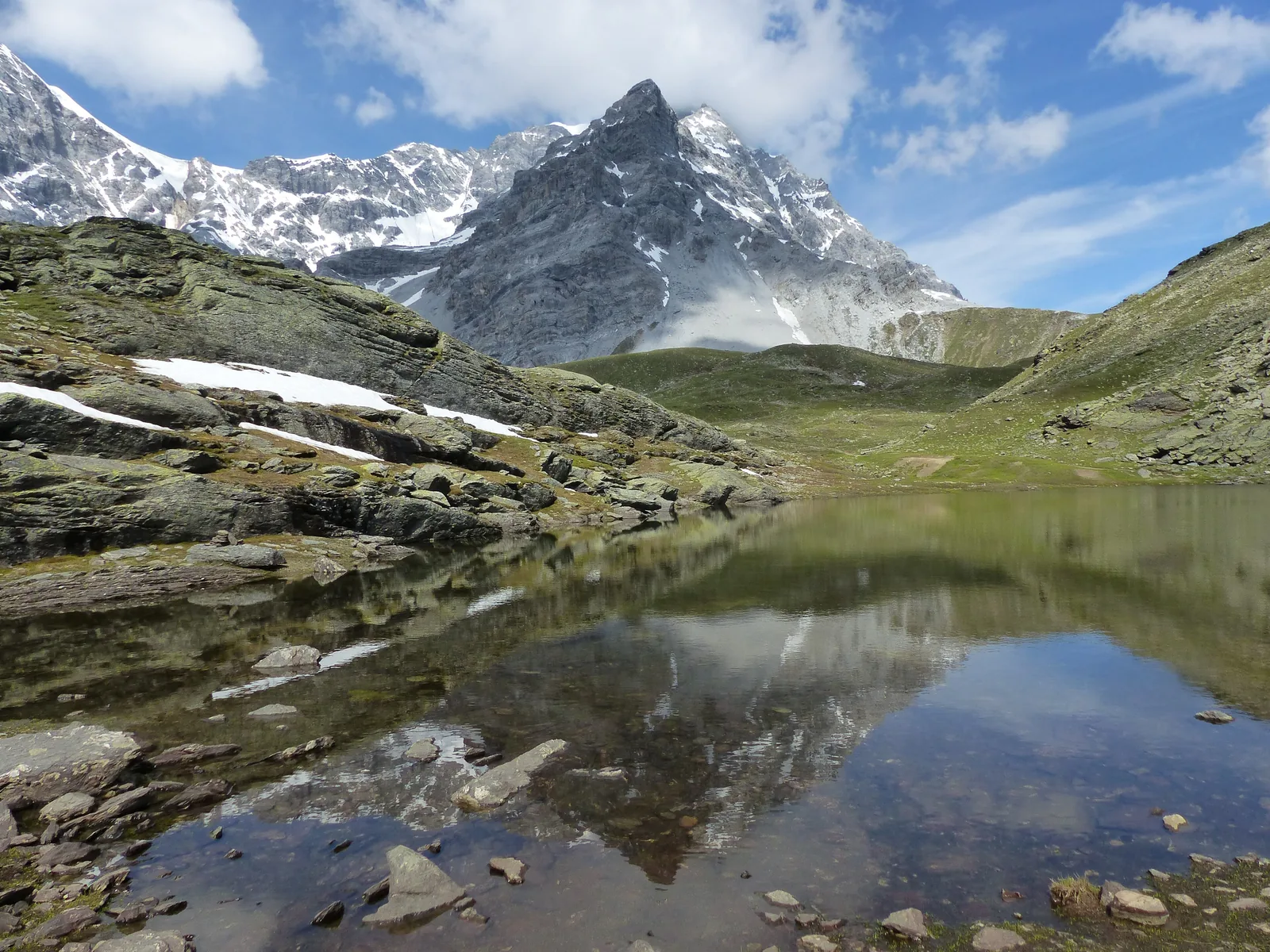 The Hintergratsee lake below the Hintergrat ridge of the Ortler in Stelvio National Park, with rocks reflected in the water