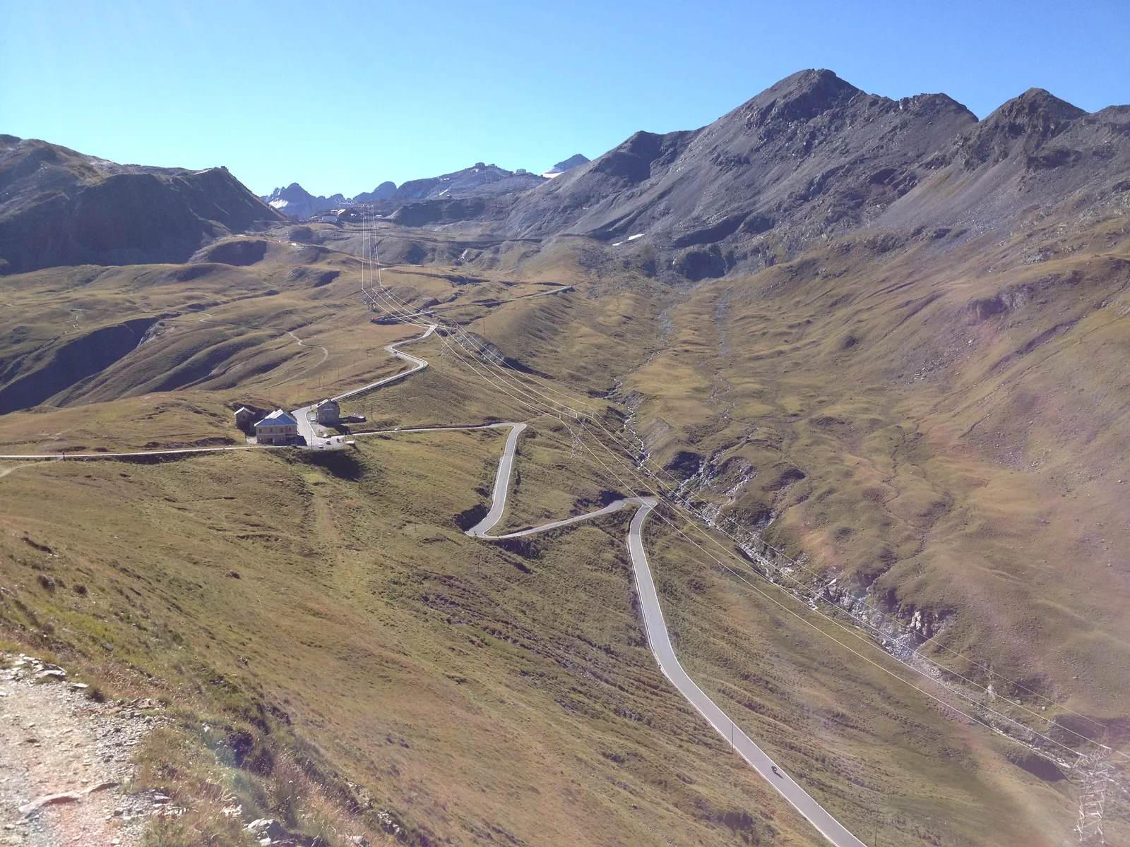 The hairpins of the Stelvio Pass road on the Lombardy side in a bare high valley, looking towards the fourth road keeper's house