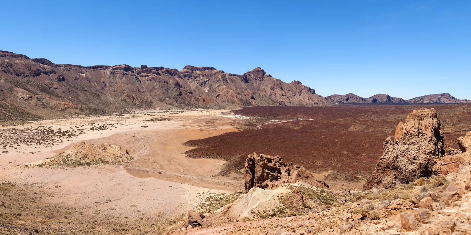 View from the Roques de García in Teide National Park across the pale Llano de Ucanca plain to the wall of the Las Cañadas caldera