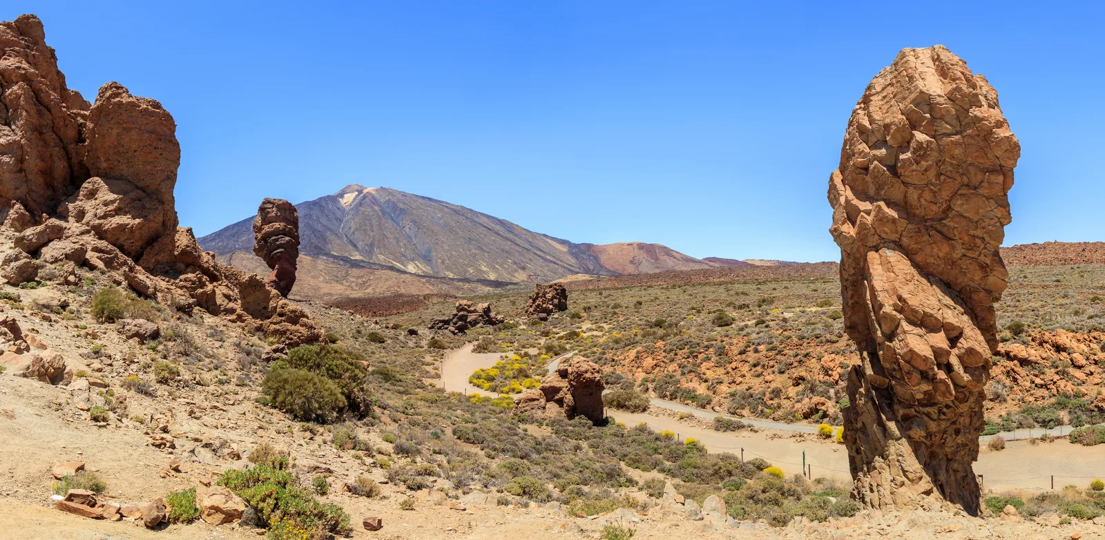 The Roques de García rock group in Teide National Park with Roque Cinchado and Roque Torrotito, Teide behind them under a blue sky