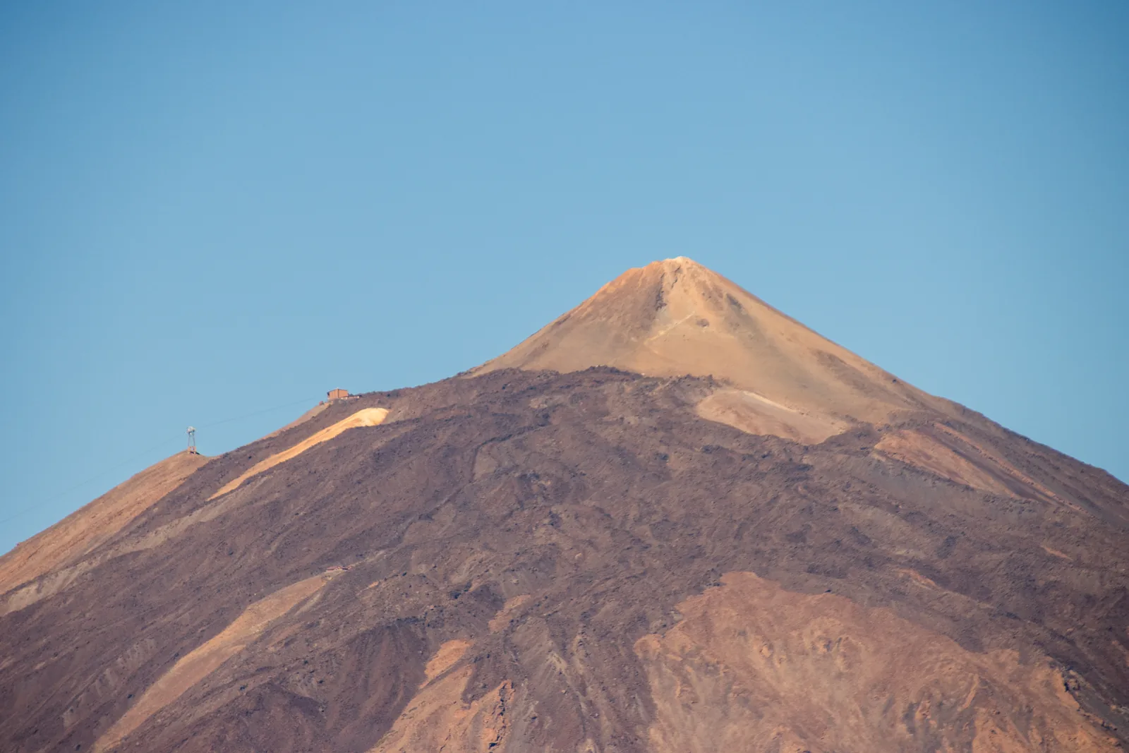 The summit cone of Teide in Teide National Park with the pale sugarloaf and the cable car top station on the left-hand slope