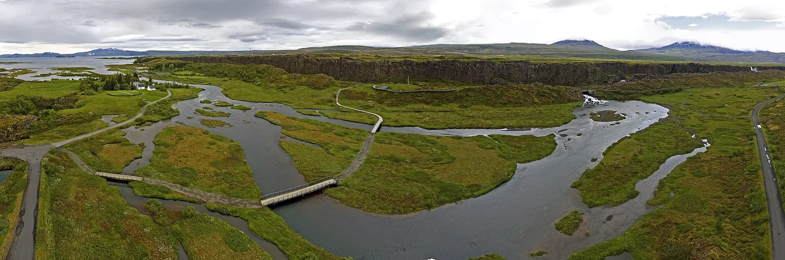 Aerial view of Þingvellir National Park: channels of the Öxará, boardwalks and paths through green meadows, mountains on the horizon