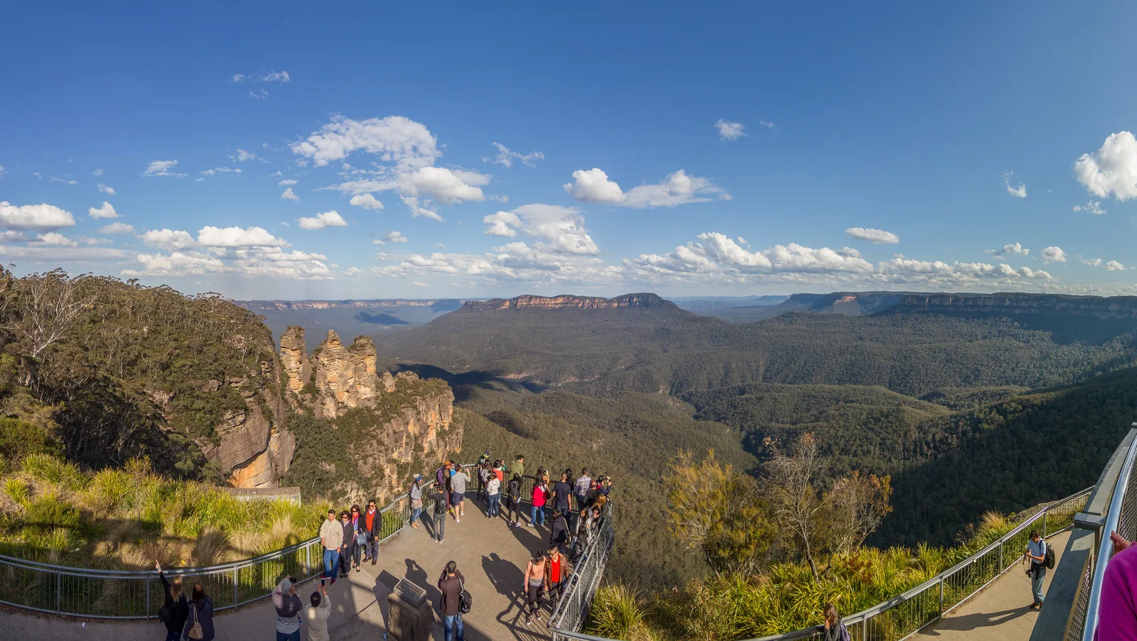 The Echo Point viewing platform near Katoomba with many visitors, behind it the Three Sisters in Blue Mountains National Park and the Jamison Valley