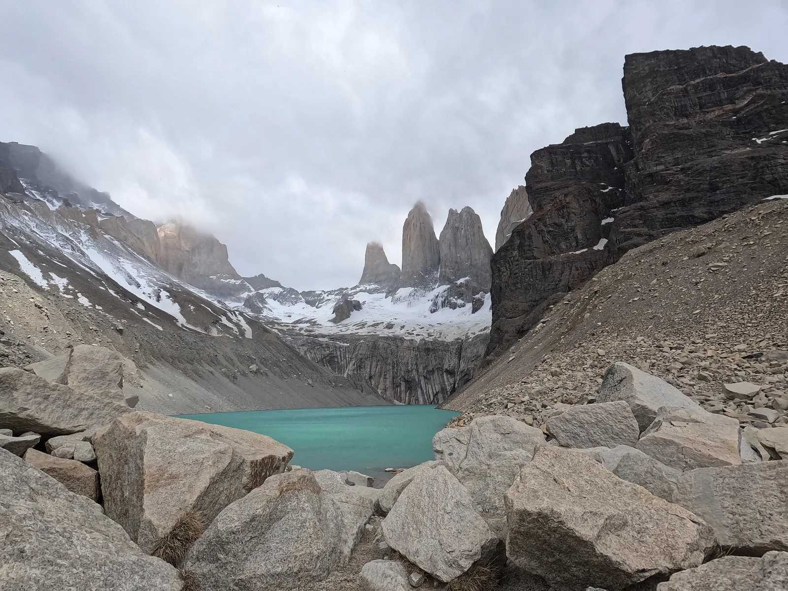 The Mirador Base Torres in Torres del Paine National Park: boulders of a moraine, the glacial lake below and the three granite towers behind
