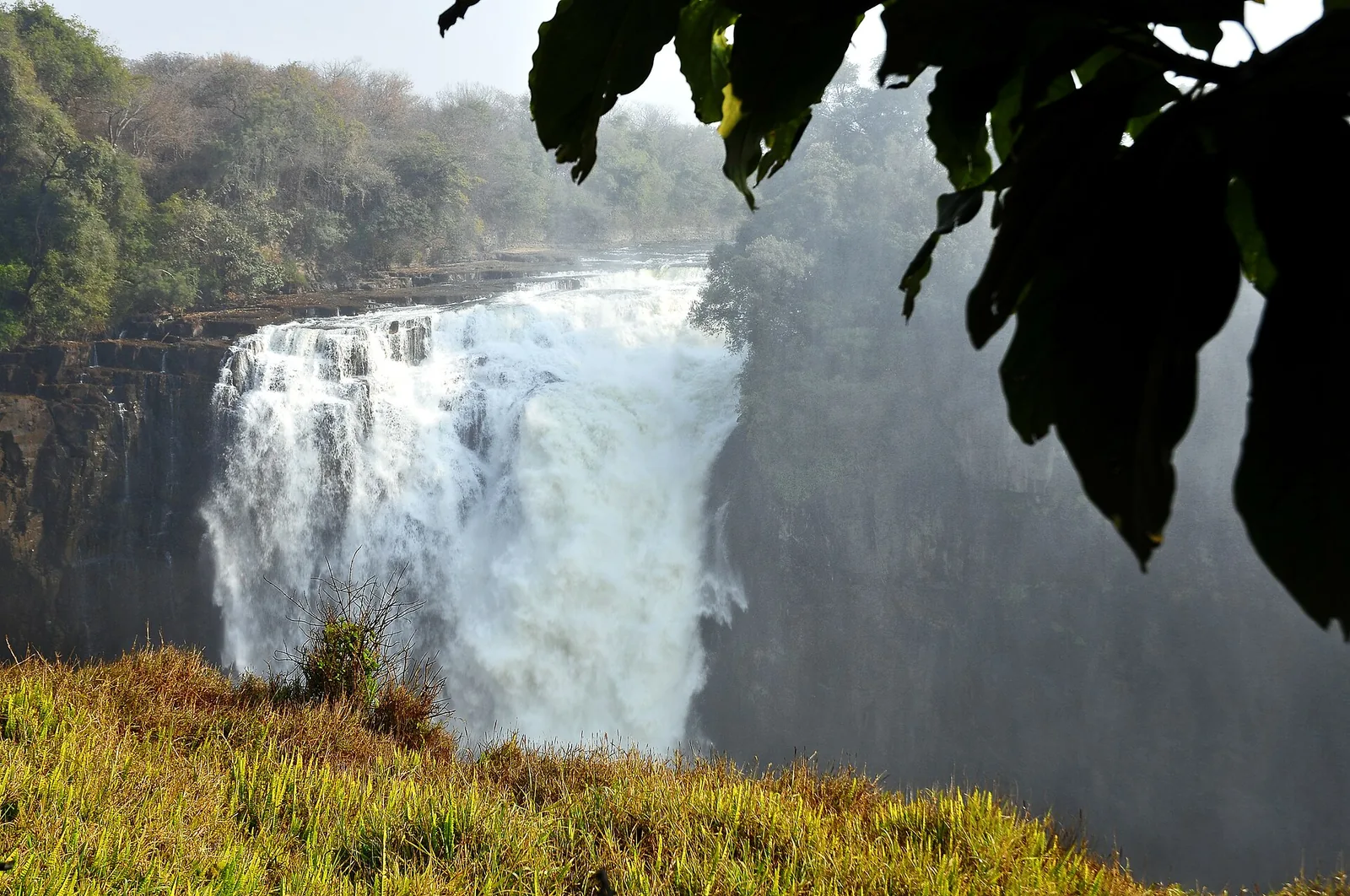 Water plunges at Devil's Cataract at Victoria Falls between green rock walls into the gorge, with spray rising