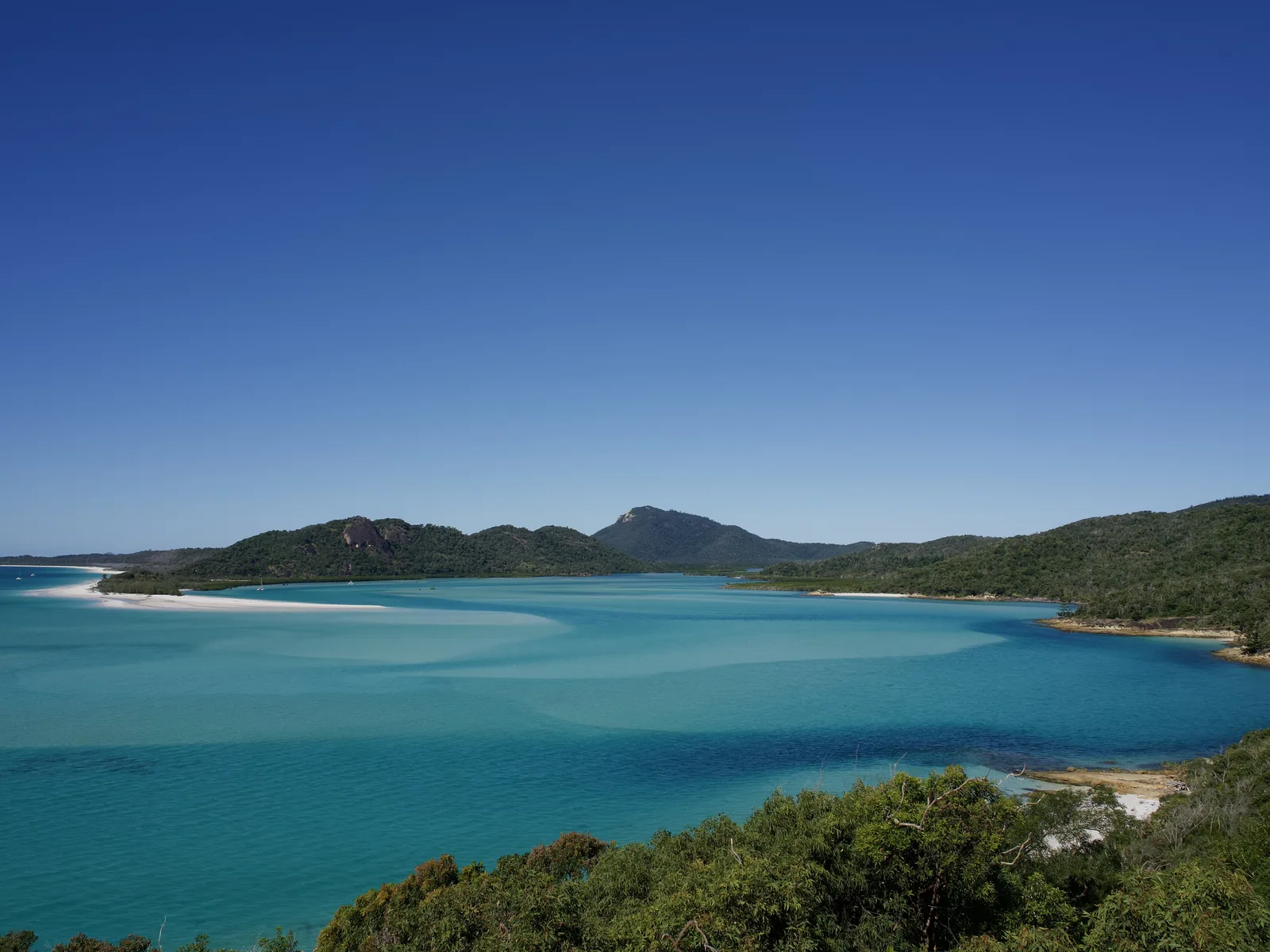 Hill Inlet in the Whitsundays on the Great Barrier Reef: swirls of white silica sand and turquoise water between forested hills