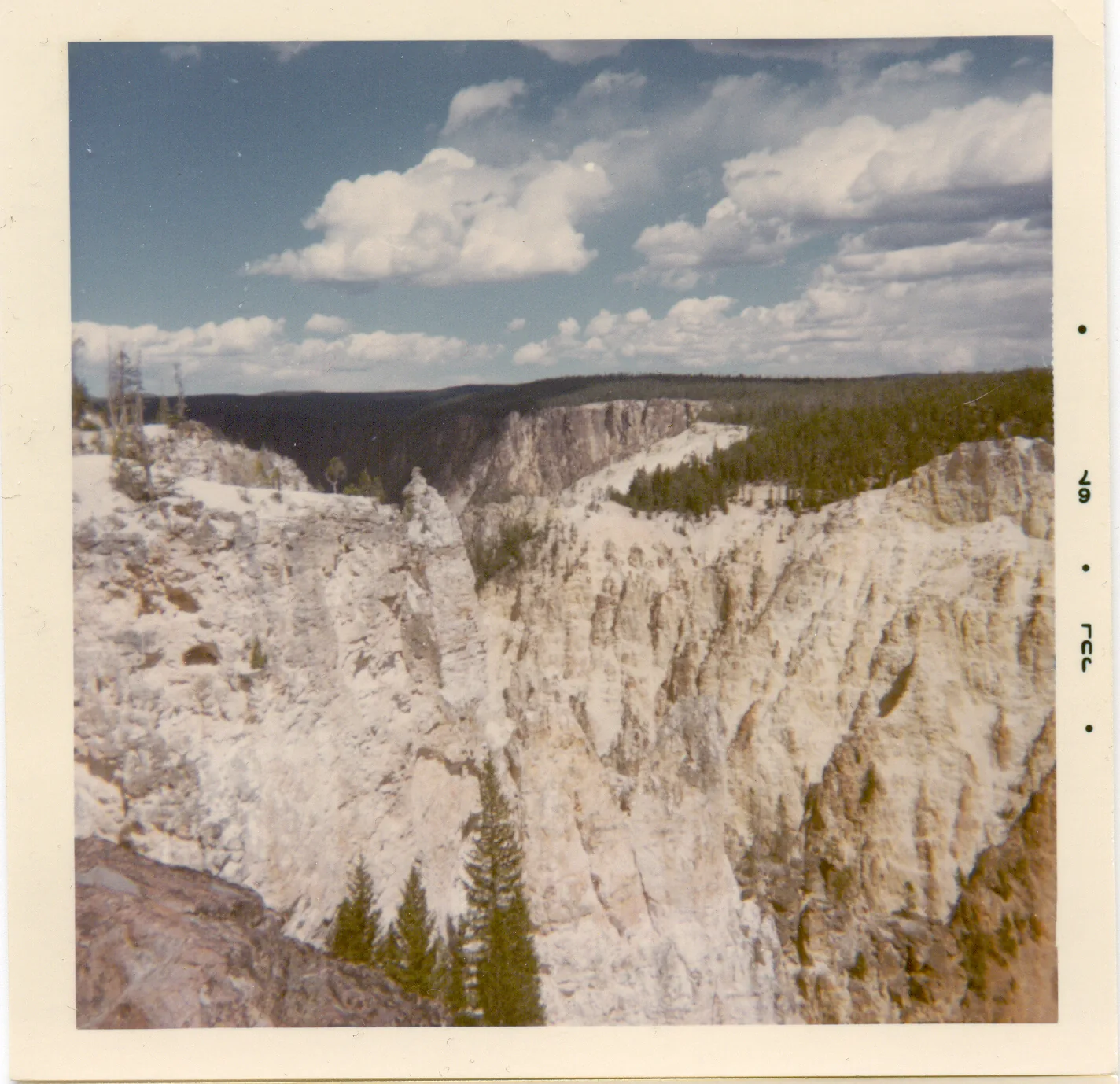The Grand Canyon of the Yellowstone in Yellowstone National Park: a deep canyon with yellow and rust-red rock walls, the river below, a tall waterfall at its head.