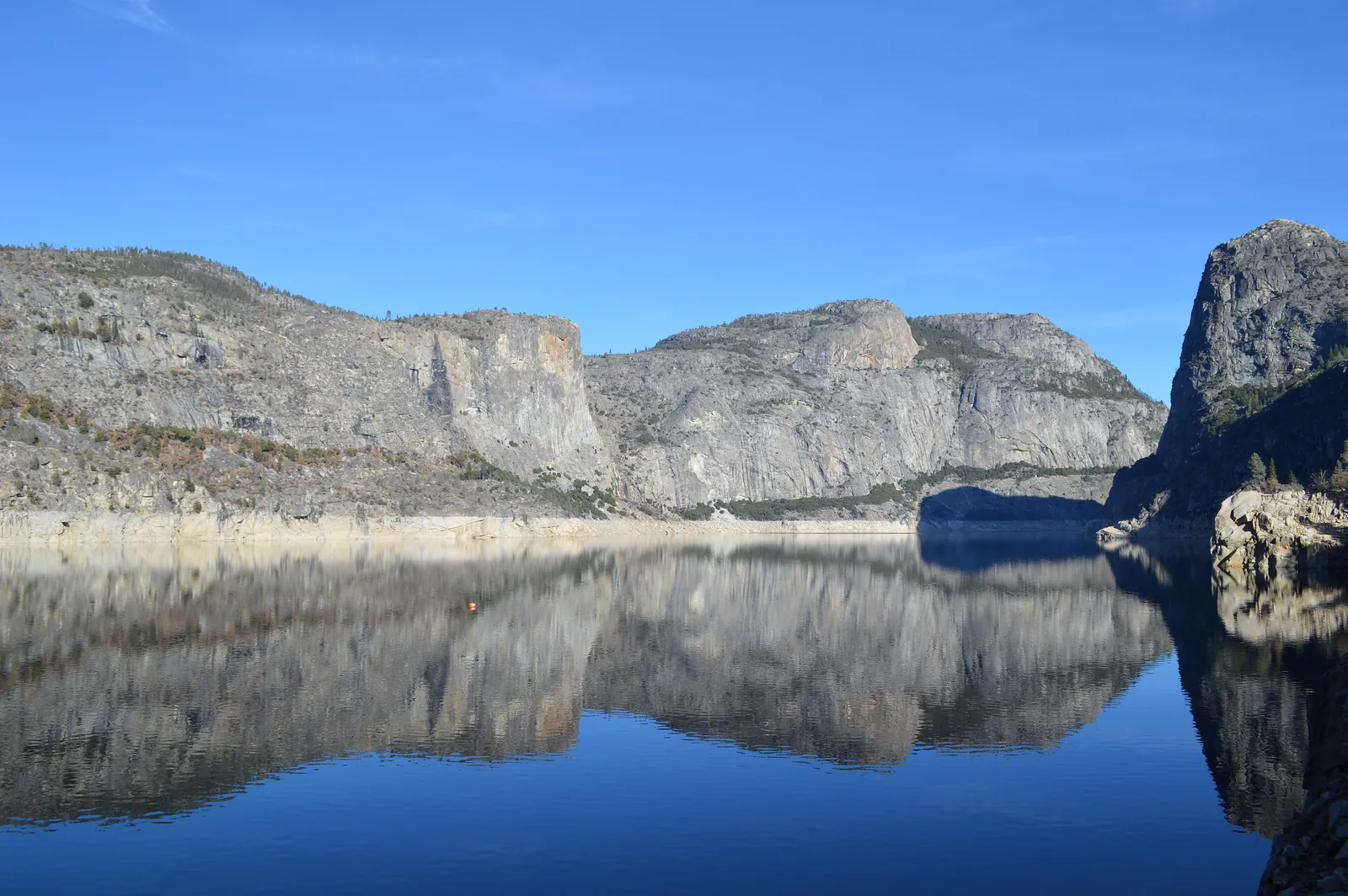 Hetch Hetchy Reservoir: granite walls and the rock nose of Kolana Rock reflected in the still, deep-blue reservoir